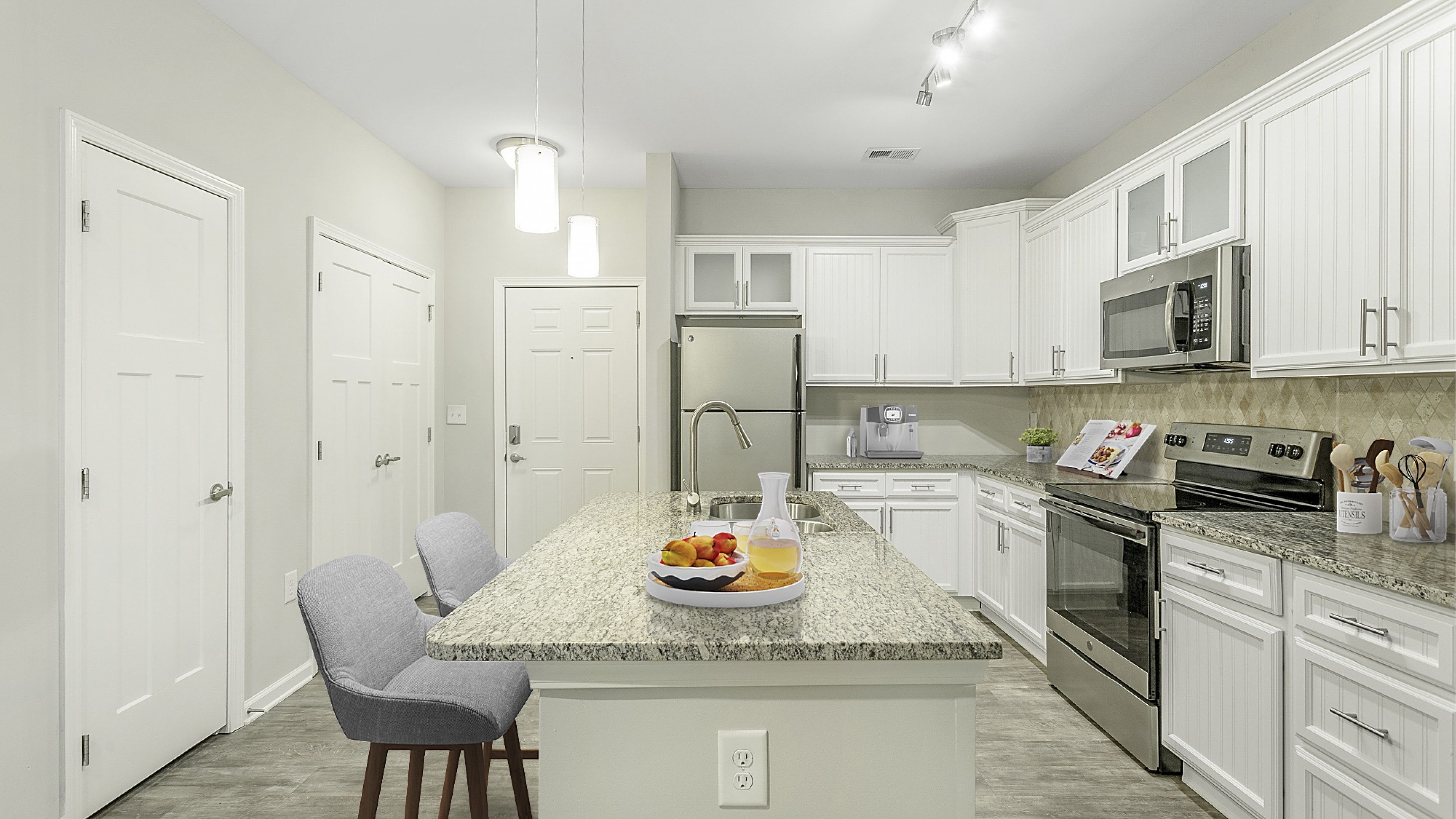 Hawthorne at Mirror Lake beautiful apartment kitchen with kitchen island, granite countertops, and white cabinets